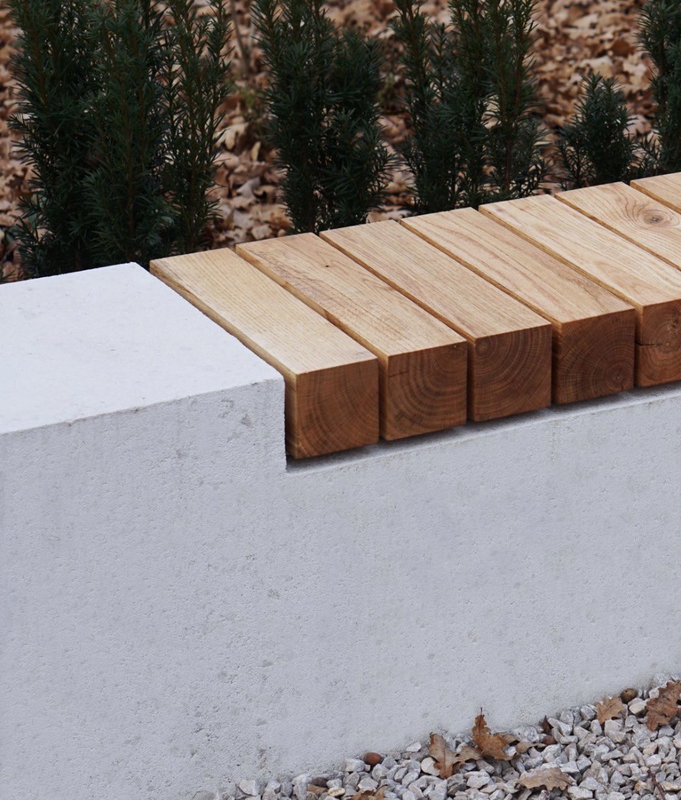 Custom timber seating beside a hedge